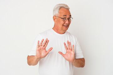 Senior american man isolated on white background rejecting someone showing a gesture of disgust.