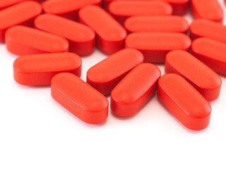 Red oval pills on white background