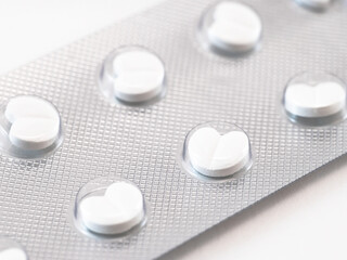 Heart-shaped white pills in blister package