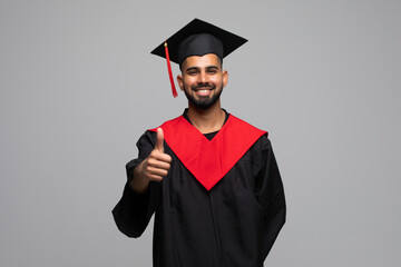 Asian Graduate man in cap and gown smile Celebrating showing thumbs up with Confident emotional so proud and happiness in Graduation day isolated on white Background