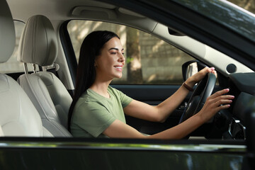 Plakat Young woman using navigation system while driving car