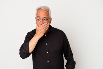 Senior american man isolated on white background covering mouth with hands looking worried.