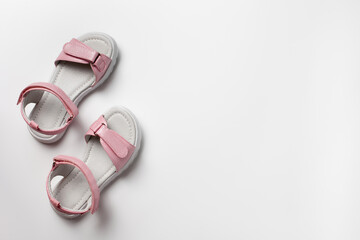 Pink children's sandals made of shiny leather with Velcro fasteners, flat white soles, solated on a white background. A pair of fashionable children's sandals for a comfortable walk. 