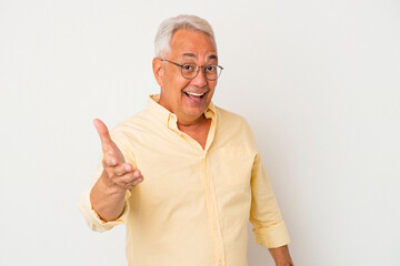 Senior american man isolated on white background stretching hand at camera in greeting gesture.