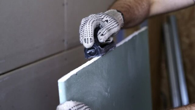 Worker Treats The Plasterboard With Plasterboard Rasp
