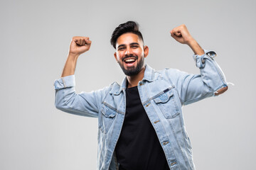 Portrait Of Smiling Man With The Fists Up Against A White Background