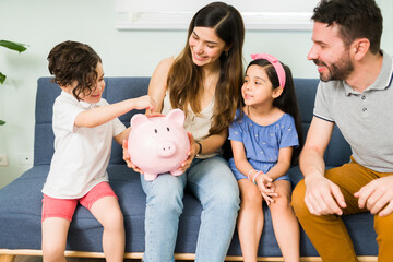 Happy mom, dad and kids saving money