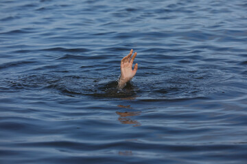 Fototapeta premium Drowning woman reaching for help in sea, closeup