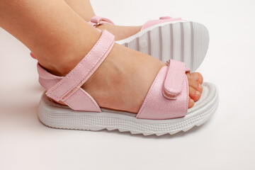 Naklejka premium Pink insulated sandals. Children's pink sandals with white soles and Velcro fasteners isolated on a white background. Fashionable children's shoes for children. 