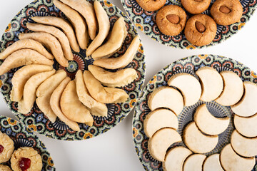Traditional Moroccan handmade cookies in a ceramic plate on white.