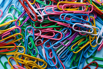 Heap of different paper clips as background, top view