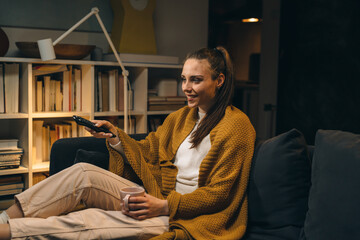 Fototapeta premium woman relaxing at home watching television. evening scene