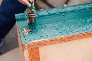 macro brush with blue or green paint updates old wooden furniture for reuse and environmental care. 
