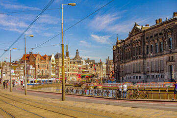 Fototapeta na wymiar Cityscape with old and modern architecture, tourists and local people in historical downtown of Amsterdam, Netherlands.