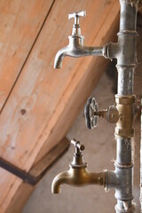 altmodische Wasserhähne an senkrechtem Wasserrohr