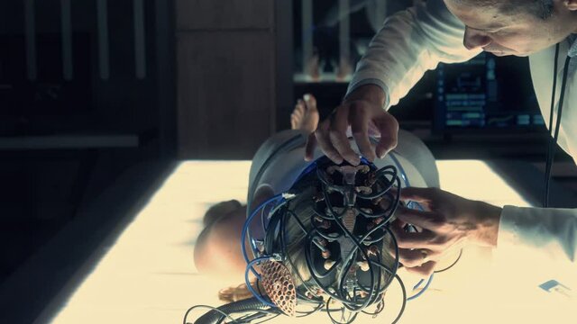 Brain Scan Interface: Scientist Connects Brain of Female Patient with Computer using Neural Headset Interface in Modern Research Facility. Doctor Works and Interacts with Brain Scanner.