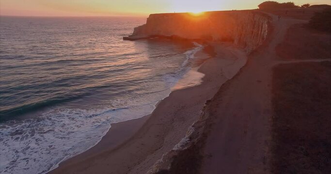 Aerial: Tranquil beach and ocean at sunset. Davenport Beach, California, USA
