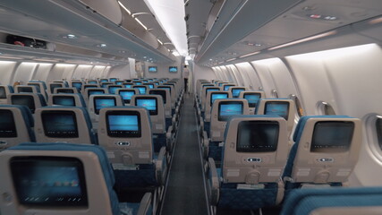 Airplane cabin with aisle and empty seats of economy class