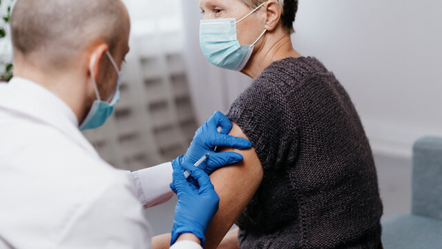 doctor vaccinating a mature woman against the coronavirus.