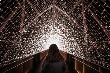 Girl walking over a fairy light bridge