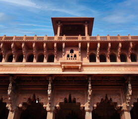 Shaped arch adorned with carved details in red sandstone - exterior detail of Jahangiri Mahal in Agra Fort, Uttar Pradesh, India