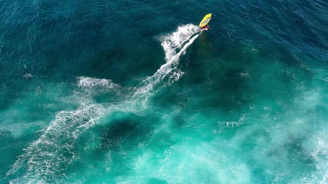 4K drone video tropical travel adventure windsurfing at a beautiful beach with crystal clear water in paradise