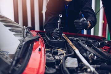 Car mechanic showing thumb up ok gesture in car service