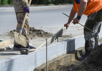 Installation of concrete blocks in cement, road construction.