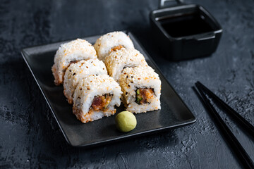 Different sushi rolls on a dark black background