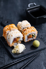 Different sushi rolls on a dark black background