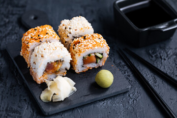 Different sushi rolls on a dark black background