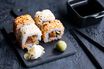 Different sushi rolls on a dark black background
