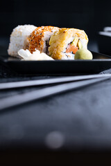 Different sushi rolls on a dark black background