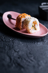 Different sushi rolls on a dark black background