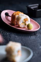 Different sushi rolls on a dark black background