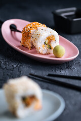 Different sushi rolls on a dark black background