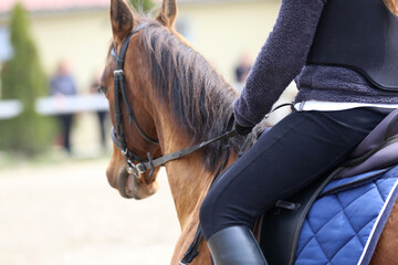 Obraz premium Old leather saddle with stirrups for show jumping race. Equestrian sport event background