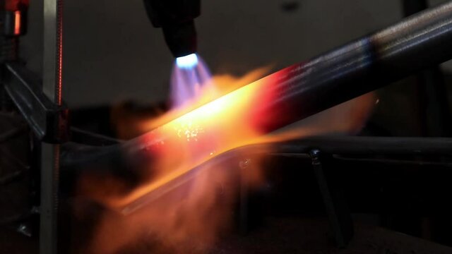 manual gas torch at work, the metal pipe is heated to red with a gas burner	