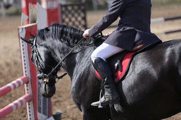 Old leather saddle with stirrups for show jumping race. Equestrian sport event background