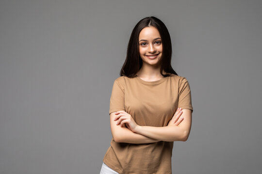 Portrait Of A Happy Woman Standing With Arms Folded On A White Background