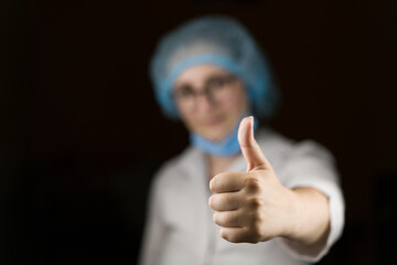 Portrait of a female doctor who likes, holds her thumbs up