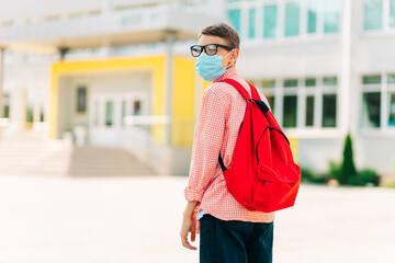 Little schoolboy wearing a mask during an outbreak of corona and flu virus, Little boy breathing through a mask while going to school