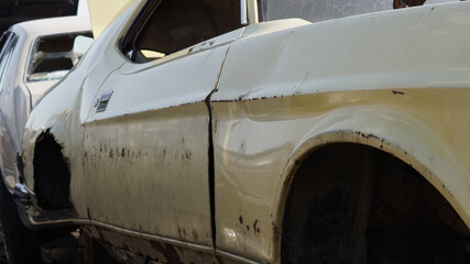 Closeup shot of a rusty damaged car in a junkyard