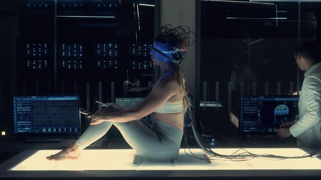 Brain Scan Interface: Scientist Monitors Brain Activity of Female Patient on Screens using Neural Headset Interface in Modern Research Facility. Connecting Brain with Computer Artificial Intelligence.