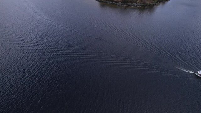 Aerial footage over a small boat on Loch Lomond near Rowardennan in Central Scotland.