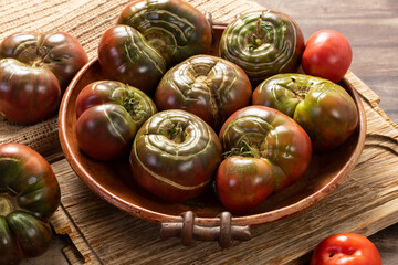 Organic tomatoes in a ceramic bowl. Organic farming or gardening concept.
