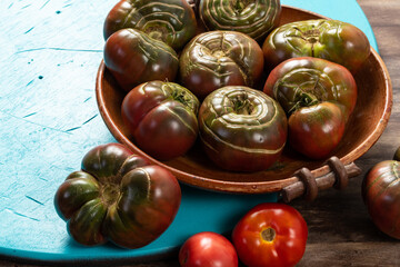 Organic tomatoes in a ceramic bowl. Organic farming or gardening concept.