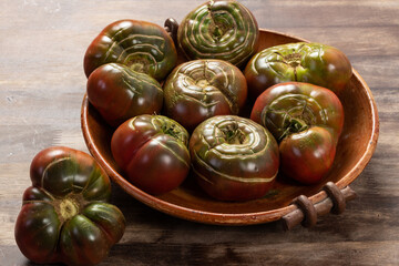 Organic tomatoes in a ceramic bowl. Organic farming or gardening concept.