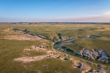 Naklejka premium morning light over arroyo and badlands in Pawnee National Grassland in northern Colorado, early summer scenery aerial view of Main Draw area