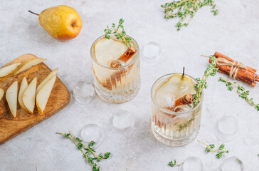 Festive summer spicy cocktail with pears and thyme on light beige background.